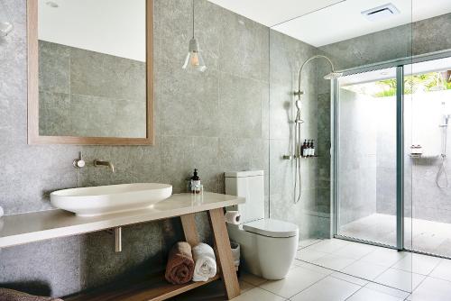 a bathroom with a sink and a toilet and a shower at Orpheus Island Lodge in Orpheus Island