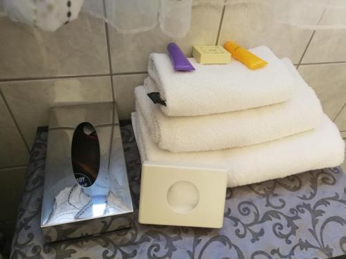 a pile of towels on a glass table in a bathroom at Boschdal Upmarket Guesthouse in Rustenburg