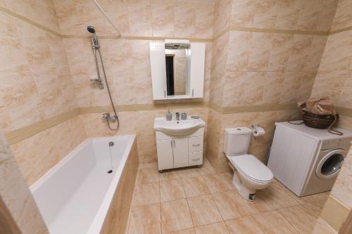 La salle de bains est pourvue d'une baignoire, de toilettes et d'un lavabo. dans l'établissement The Base Apartments, à Chişinău