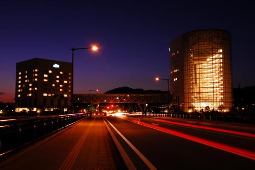 a city street at night with buildings and street lights at Hotel Kyocera in Kirishima