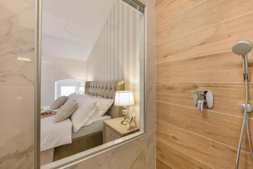 ein Schlafzimmer mit einem Spiegel neben einem Bett in der Unterkunft Harvey's luxury rooms in Zadar