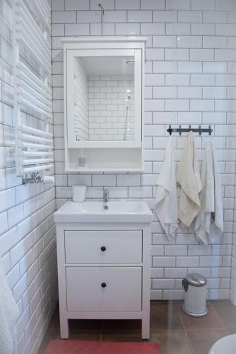 a white bathroom with a sink and a mirror at Lipowy Dwór in Szczecinek