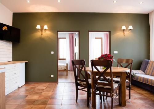 - une cuisine et une salle à manger avec une table et des chaises dans l'établissement Lipowy Dwór, à Szczecinek