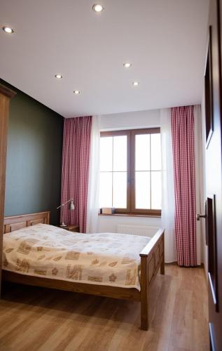 a bedroom with a bed and a large window at Lipowy Dwór in Szczecinek