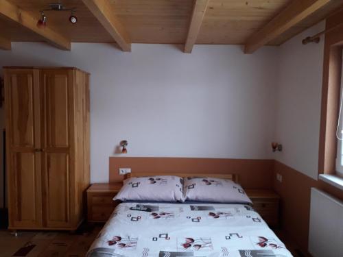 a bedroom with a bed and a wooden cabinet at Chalupa Vaclav in Terchová
