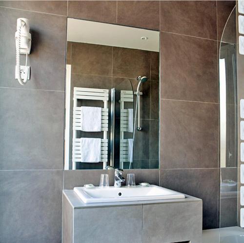 a bathroom with a sink and a mirror at Hotel Des Arenes in Paris