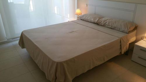 1 dormitorio con 1 cama grande y lámpara. en Apartamento con fantásticas vistas al mar, en Benidorm