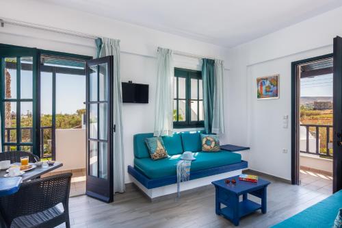 a living room with a blue couch and windows at Villa Chantaloukas in Kokkíni Khánion