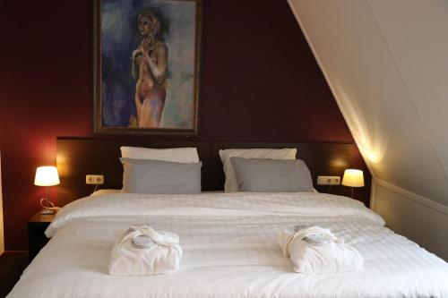 a bedroom with a large bed with towels on it at Wellness Suites Dellewal in West-Terschelling