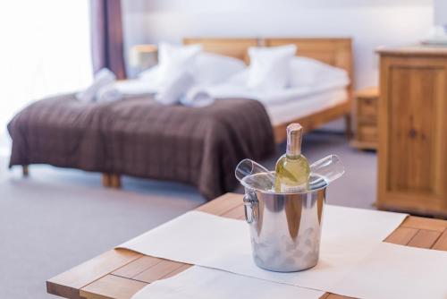 a bottle of wine sitting on a table in a bedroom at Orlicka Skała in Zieleniec