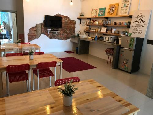 a restaurant with wooden tables and red chairs at Check In Lodge in Kuching