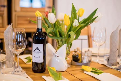 a table with a bottle of wine and a vase of flowers at Orlicka Skała in Zieleniec