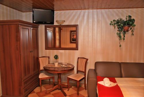 a living room with a table and chairs and a television at Berényi Fogadó in Nagykanizsa