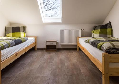 2 Betten in einem kleinen Zimmer mit Fenster in der Unterkunft BoardingHouse Quickborn in Quickborn