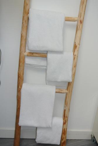 a stack of white towels on a wooden ladder at Appartement 't Loft in Zandvoort
