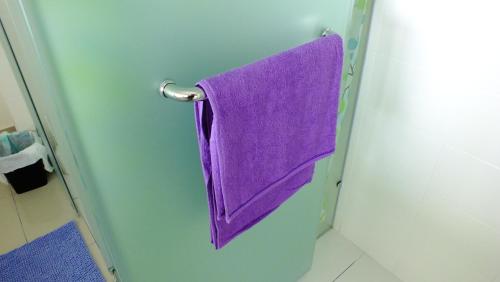 una toalla púrpura colgada en una puerta del baño en Zen Studio @ Trefoil Setia Alam, en Shah Alam