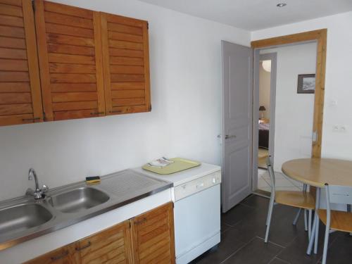 a kitchen with a sink and a table at Gîtes vallée de Munster in Muhlbach-sur-Munster
