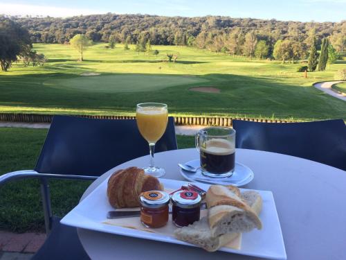 a plate of food and a glass of orange juice and bread at Résidence Du Golf in Nîmes