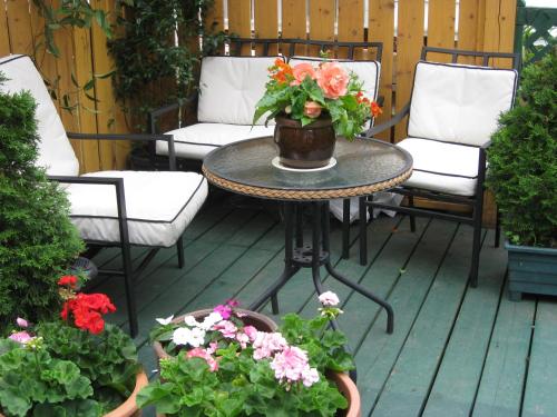 a patio with a table and chairs and flowers at B&B Le Transit in Quebec City