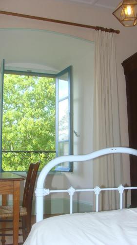 a bedroom with a bed and a window and a table at Château des Grèzes in Agnat