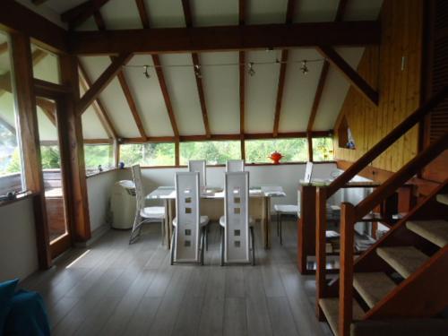une salle à manger avec une table et des chaises blanches dans l'établissement Chalet Contemporain Plein Nature, à Altenbach