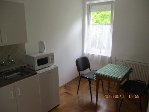 a small kitchen with a table and a microwave at Boglárka Apartmanház in Balatonfüred