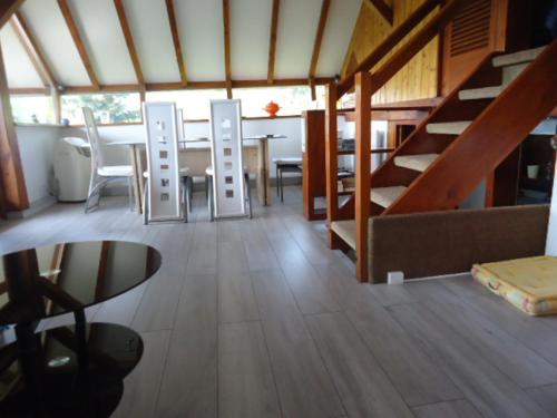 a living room with a table and chairs and stairs at Chalet Contemporain Plein Nature in Altenbach