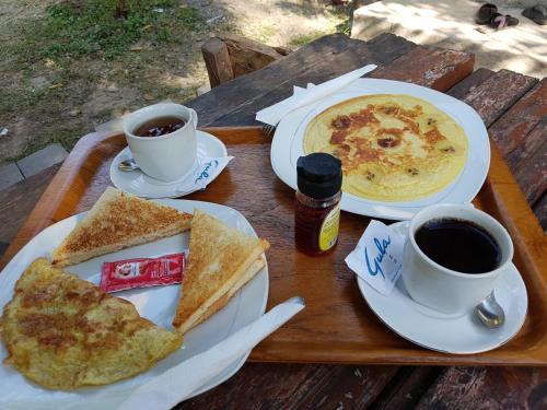 een dienblad met twee borden eten en twee kopjes koffie bij Kuta Lodge Homestay in Kuta Lombok
