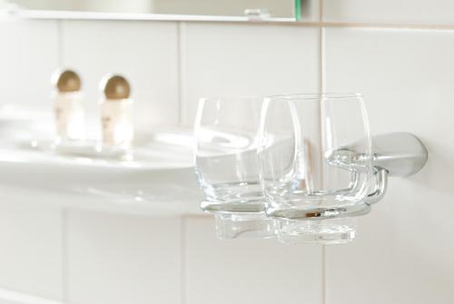 a pair of glasses hanging on a holder in a bathroom at Vitalhotel Weisse Elster in Bad Elster