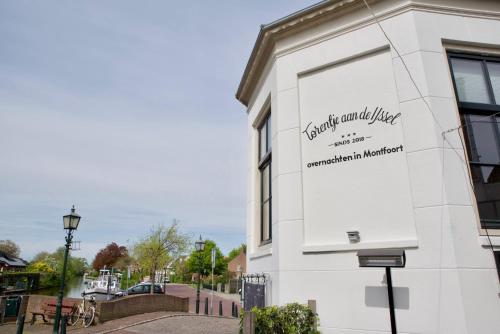 a white building with a sign on the side of it at Het Torentje aan de IJssel in Montfoort