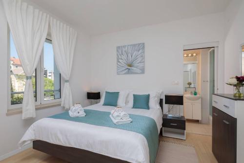 a bedroom with a large bed with blue and white at Apartments CenterLink in Split