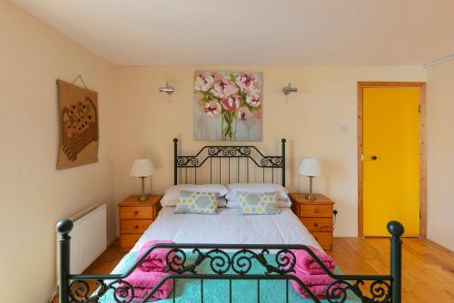 1 dormitorio con 1 cama y una pintura en la pared en Sutton Cottage en Wexford