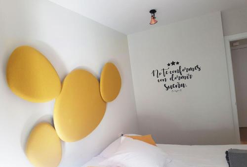 a bedroom with a bed with yellow ears on the wall at Smart Urban Orio in Orio