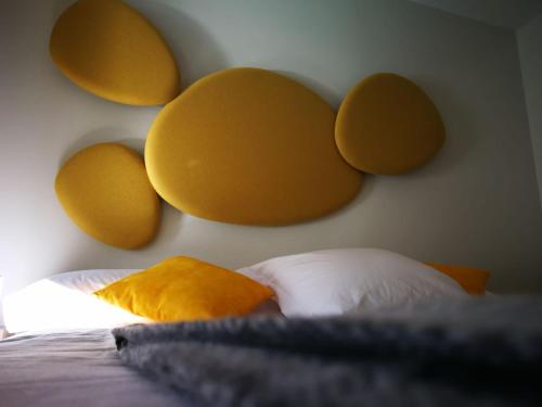 a bedroom with a headboard with yellow and orange pillows at Smart Urban Orio in Orio