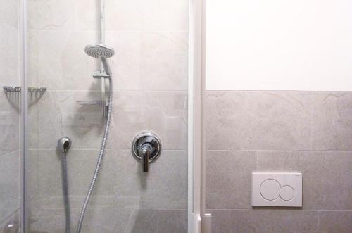 a shower with a shower head in a bathroom at Hotel Pension Schweitzer in Silandro