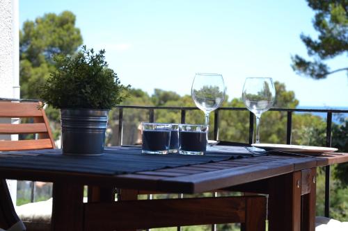 カレリャ・デ・パラフルジェリにあるApartamento recien reformado a 300 metros del marのワイングラス2杯と鉢植えのテーブル