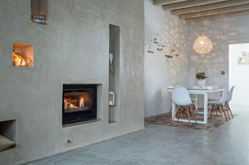 a living room with a table and a fireplace at Melograno Villas in Astypalaia