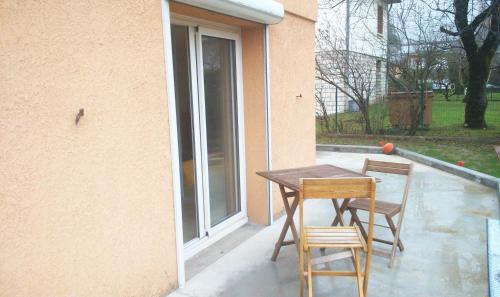 - une table en bois et 2 chaises sur la terrasse dans l'établissement Loft sympa à Sassenage, à Sassenage