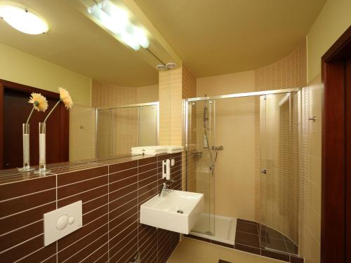 a bathroom with a sink and a shower at Apartamenty Złota Nić in Opole