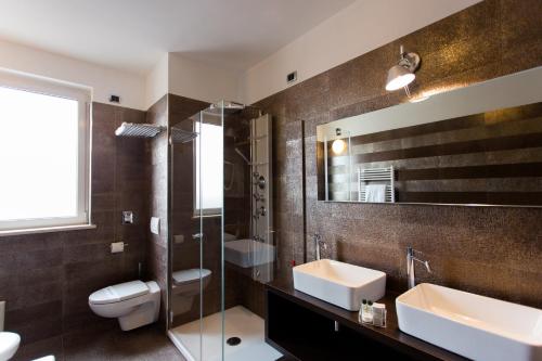 een badkamer met een wastafel, een toilet en een spiegel bij Air Palace Hotel in Leinì