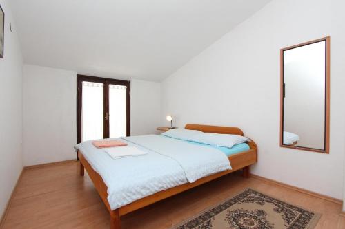 - une chambre avec un lit, un miroir et un tapis dans l'établissement Apartments Lora, à Rovinj