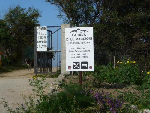 a sign that is in front of a gate at Agriturismo La Tana di Lu Maccioni in Santa Teresa Gallura
