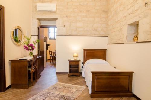 Un dormitorio con una cama, un escritorio y un lavabo. en Agriturismo Margione, en Módica