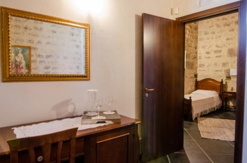 Habitación con escritorio y dormitorio con cama. en Agriturismo Margione, en Módica