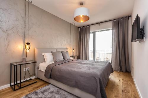 a bedroom with a bed and a large window at Warm Amber Suites Brașov in Braşov