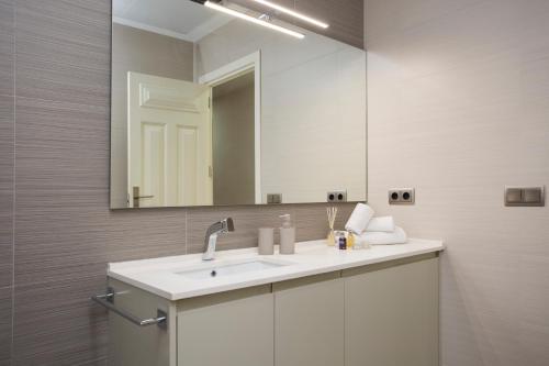 W łazience znajduje się umywalka i lustro. w obiekcie SingularStays Santa Clara w Walencji