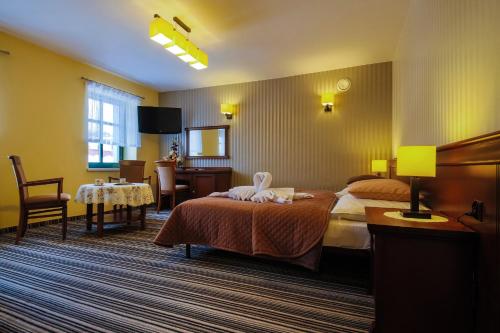 ヴィスワにあるApartamenty przy Głównym Deptakuのベッド2台とテーブルが備わるホテルルームです。