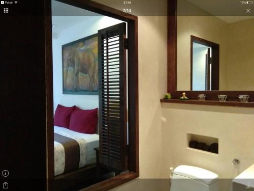 ein Badezimmer mit einem Schlafzimmer mit einem Bett und einem Spiegel in der Unterkunft Away Las Tortugas at Hua Hin in Khao Tao