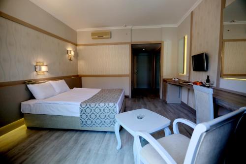 a small hotel room with a bed and a table at Grand Ring Hotel in Beldibi