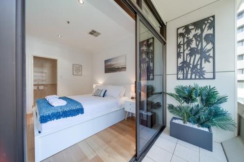 a bedroom with a bed and a glass wall at York Apartments on Grenfell in Adelaide